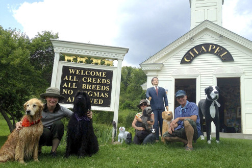 The Dog Chapel sign serves as backdrop for hundreds of family portraits.  Pictured here, Elizabeth with Fernandina and Dovekie, Ana with Tomas, and Chris nestled among Stephen's collection of dog statuettes